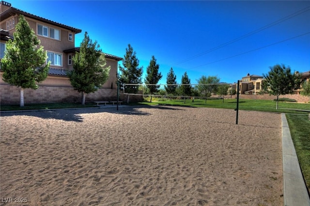 view of community featuring volleyball court and a yard