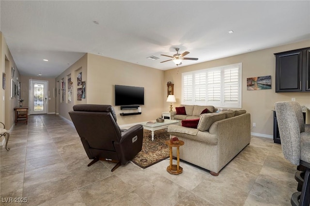 living room featuring ceiling fan and a wealth of natural light