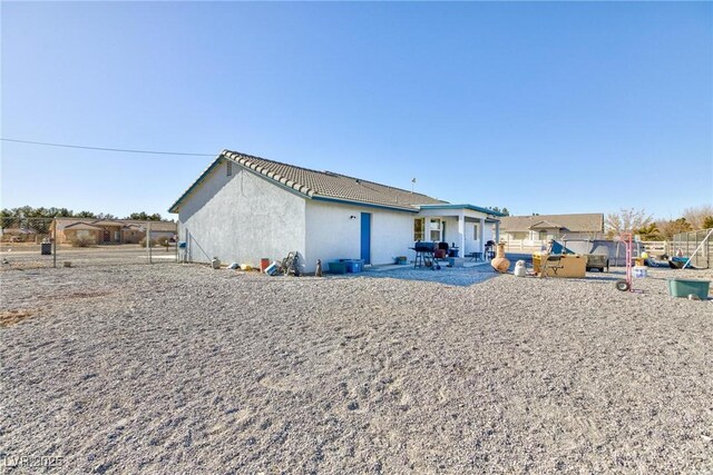 back of house featuring a hot tub and a patio