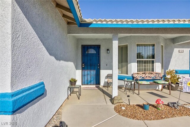 view of exterior entry featuring a patio