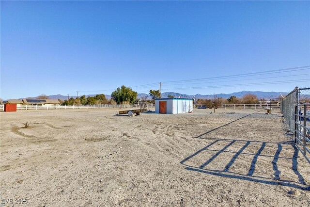 view of yard with a rural view and a mountain view