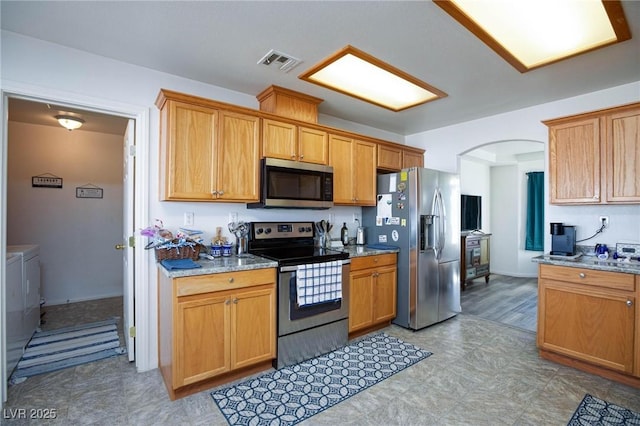 kitchen with light stone counters and appliances with stainless steel finishes