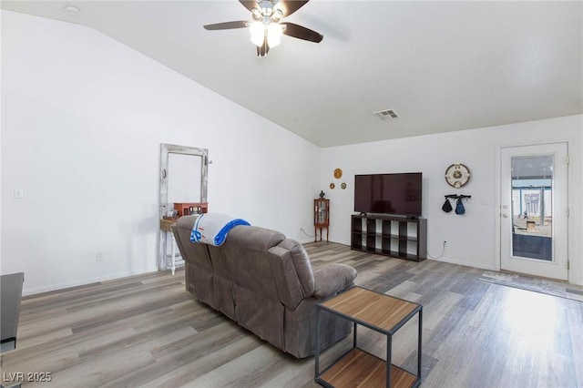 living room with ceiling fan, light hardwood / wood-style flooring, and vaulted ceiling