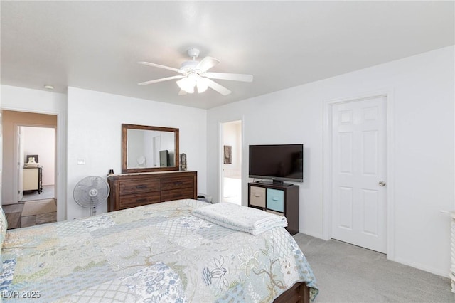 bedroom featuring ceiling fan, connected bathroom, and light carpet