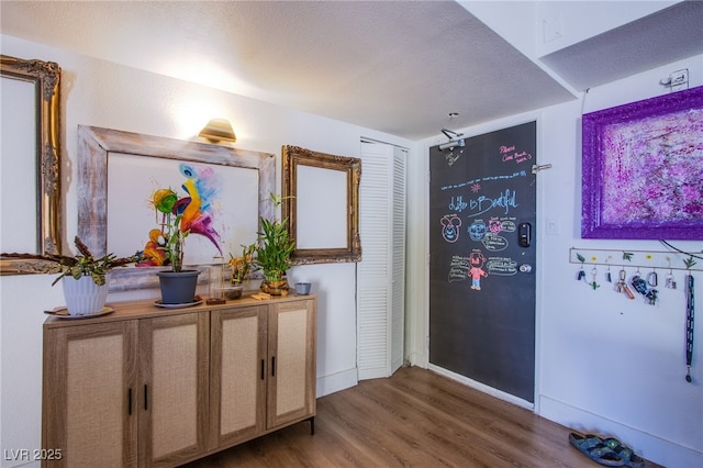 corridor featuring a textured ceiling and dark hardwood / wood-style floors