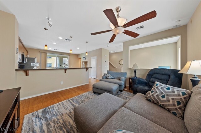 living room with ceiling fan and light wood-type flooring