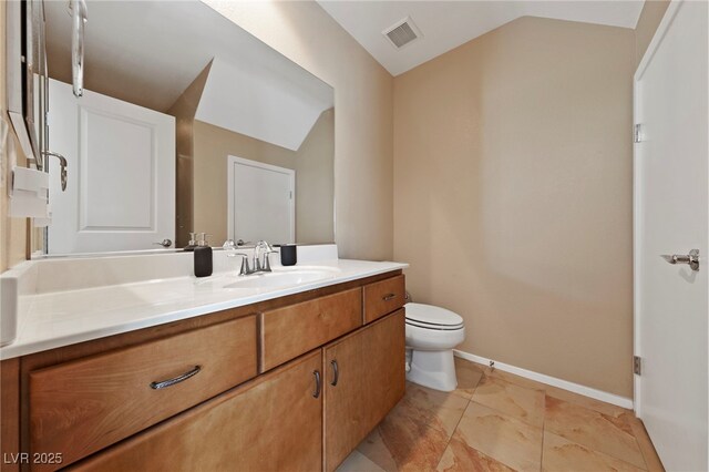 bathroom featuring toilet, tile patterned flooring, lofted ceiling, and vanity