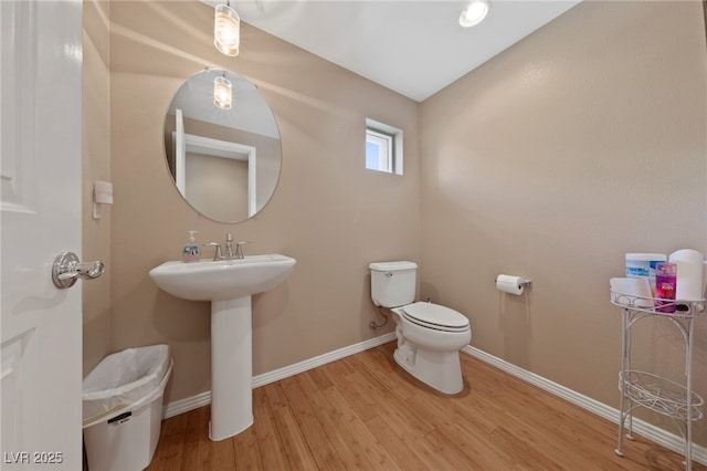 bathroom featuring toilet, wood-type flooring, and sink