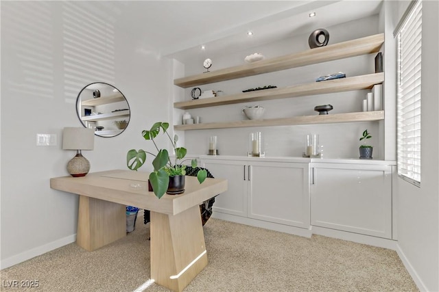 bar featuring white cabinets and light colored carpet