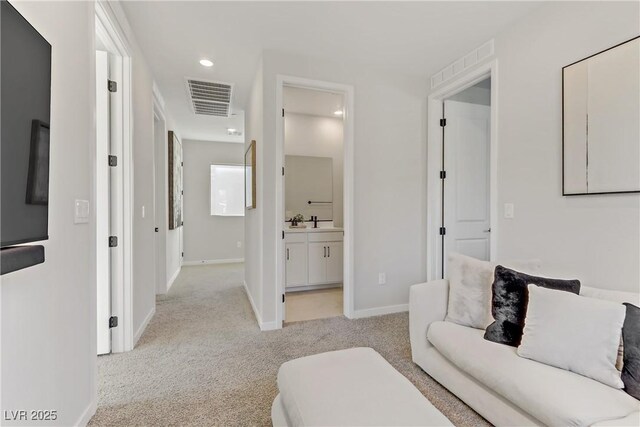 living room with sink and light colored carpet