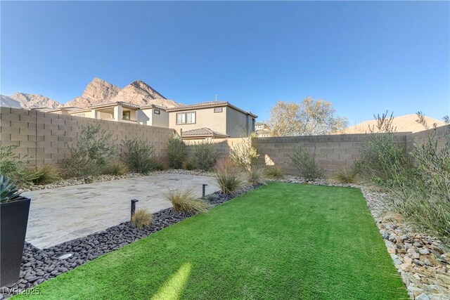 view of yard featuring a patio and a mountain view