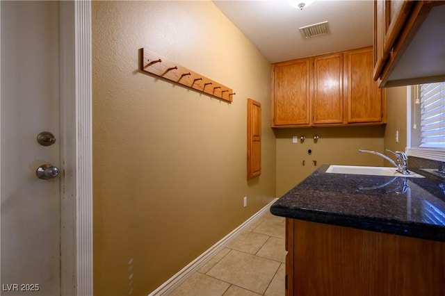 laundry room with sink, light tile patterned floors, cabinets, and hookup for a washing machine