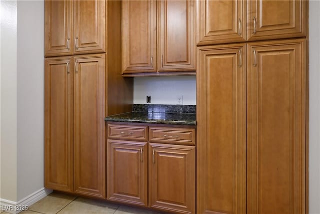 kitchen featuring dark stone counters and light tile patterned flooring