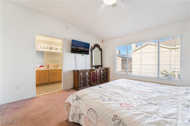 carpeted bedroom with lofted ceiling, ensuite bath, and multiple windows