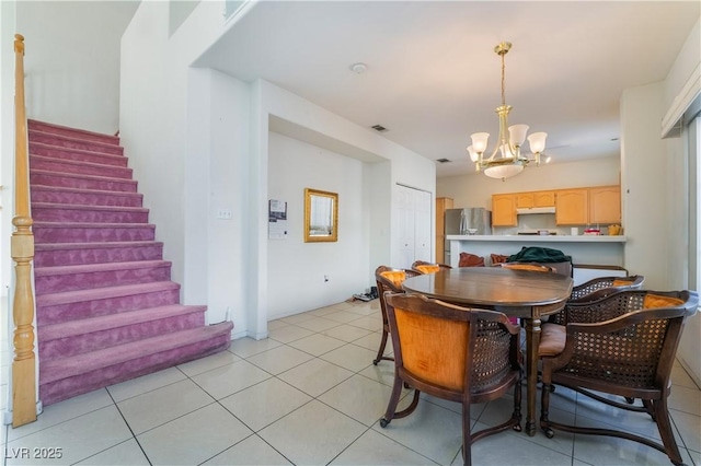 tiled dining area featuring an inviting chandelier