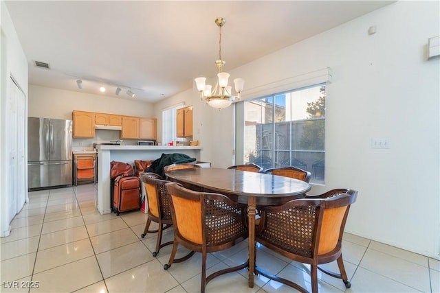 tiled dining space featuring a chandelier