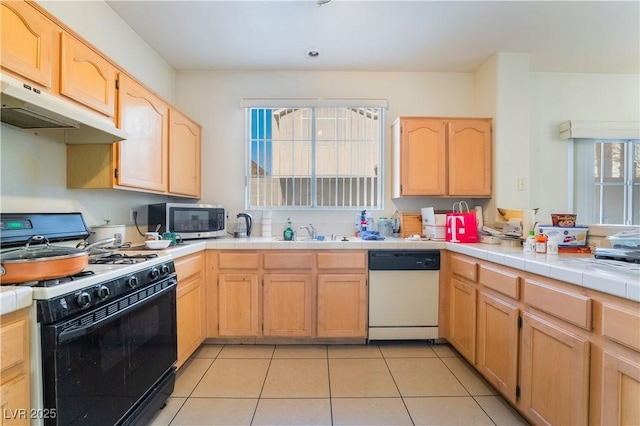 kitchen featuring dishwasher, tile countertops, range with gas stovetop, light tile patterned flooring, and sink