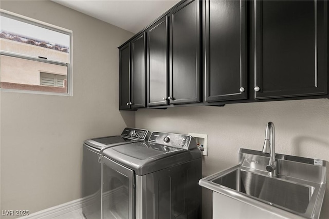 laundry area featuring washer and dryer, cabinets, and sink