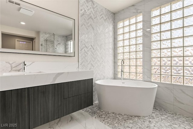 bathroom featuring vanity, tile walls, and separate shower and tub