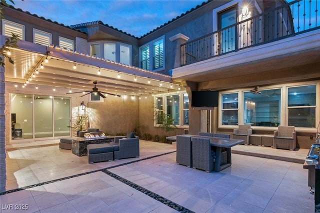 view of patio with a balcony, ceiling fan, and an outdoor living space