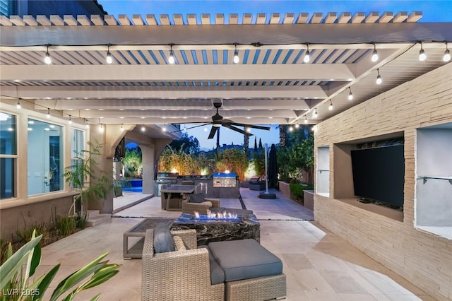 view of patio with ceiling fan, area for grilling, and an outdoor kitchen