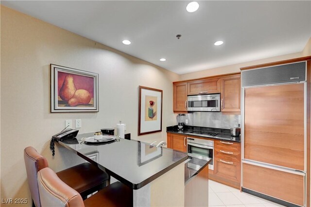 kitchen featuring appliances with stainless steel finishes, light tile patterned flooring, and tasteful backsplash