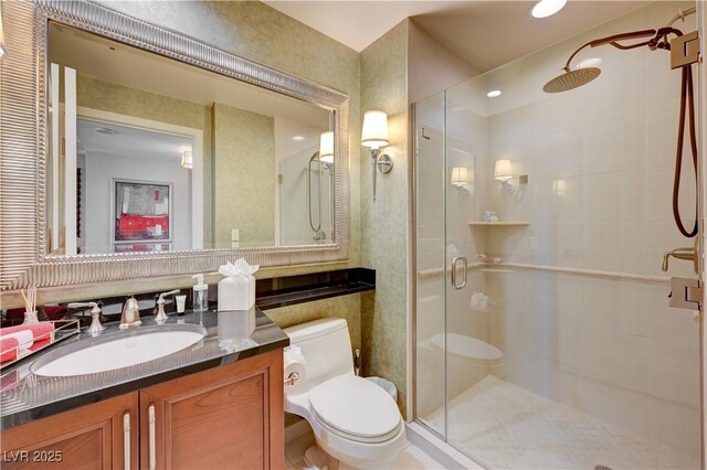 bathroom featuring vanity, a shower with shower door, and toilet