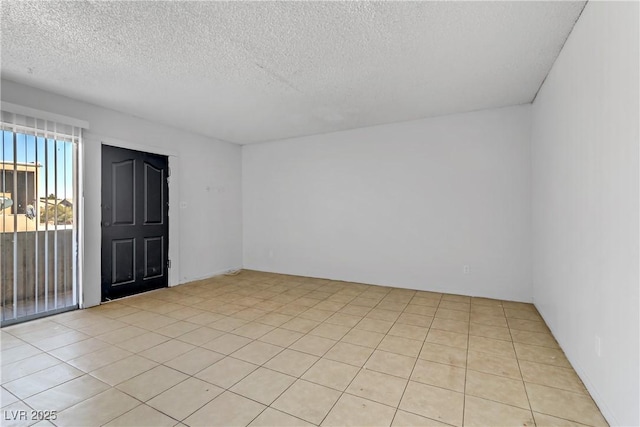 unfurnished room featuring light tile patterned flooring and a textured ceiling