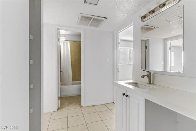 bathroom with a textured ceiling, vanity, tile patterned flooring, and shower / bathtub combination with curtain