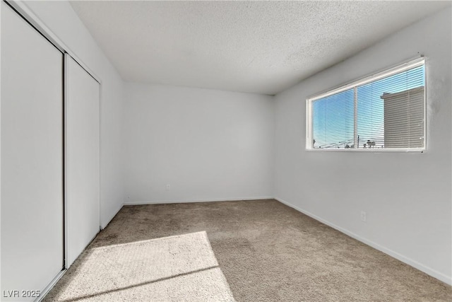 carpeted spare room featuring a textured ceiling