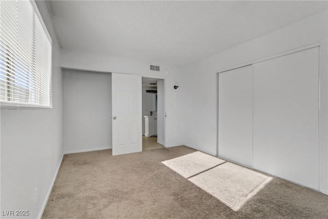 unfurnished bedroom featuring a closet and light carpet