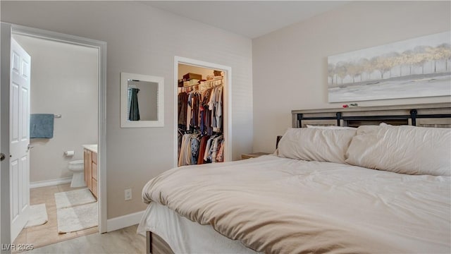 bedroom featuring a walk in closet, connected bathroom, and a closet