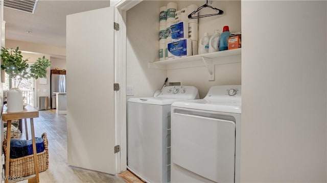 washroom featuring light hardwood / wood-style floors and separate washer and dryer