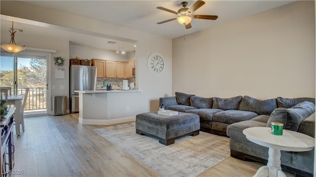 living room with ceiling fan and light hardwood / wood-style flooring