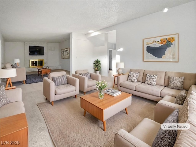 carpeted living room featuring a fireplace and a textured ceiling