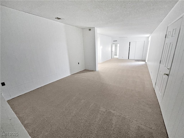 unfurnished room with a textured ceiling and carpet