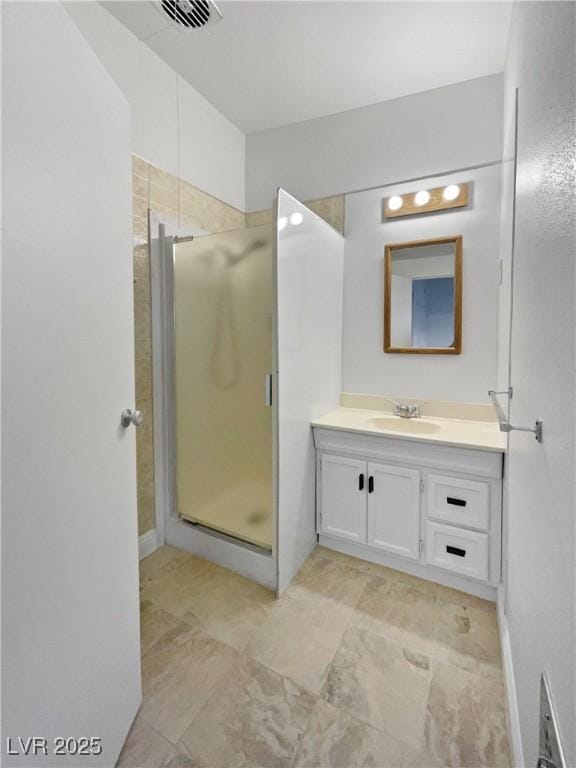 bathroom with a shower with door and vanity