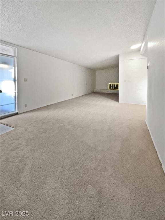 empty room featuring a textured ceiling and light colored carpet