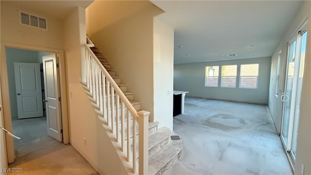 stairs featuring concrete flooring