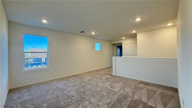 carpeted spare room with baseboards, plenty of natural light, visible vents, and recessed lighting