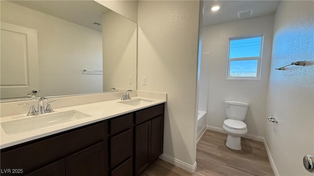 full bathroom featuring toilet, baseboards, a sink, and wood finished floors