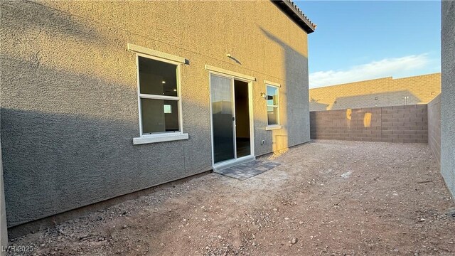 exterior space with a fenced backyard and stucco siding