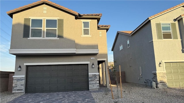 view of front of property with stone siding, a tile roof, and stucco siding