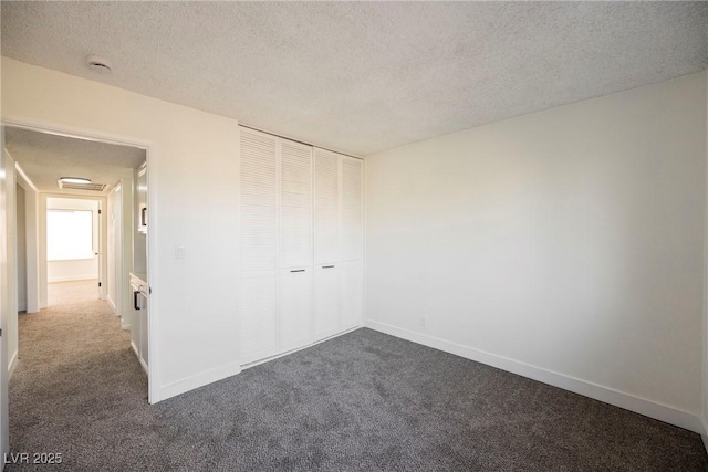 carpeted empty room with a textured ceiling