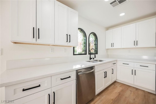 kitchen with sink, light hardwood / wood-style flooring, white cabinetry, and stainless steel dishwasher