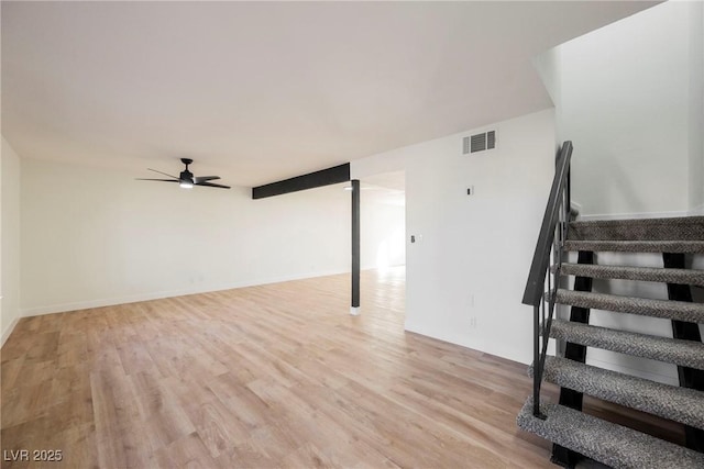 basement featuring ceiling fan and light hardwood / wood-style floors