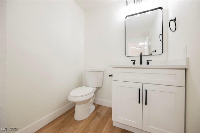 bathroom featuring toilet, wood-type flooring, and vanity