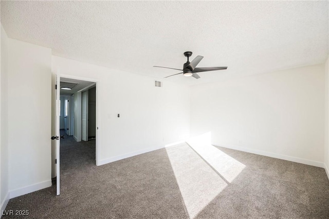 carpeted spare room with a textured ceiling and ceiling fan