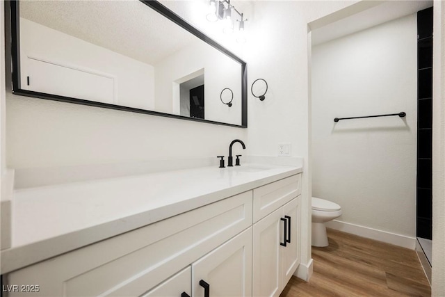 bathroom with hardwood / wood-style floors, vanity, and toilet