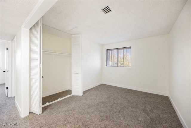 unfurnished bedroom featuring a textured ceiling, a closet, and carpet flooring